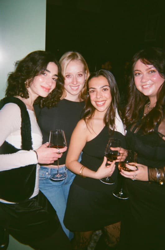 Four friends with wine glasses at a Wingmate night out